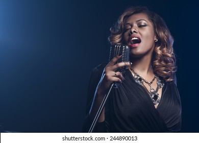 Beautiful African woman singing with the microphone