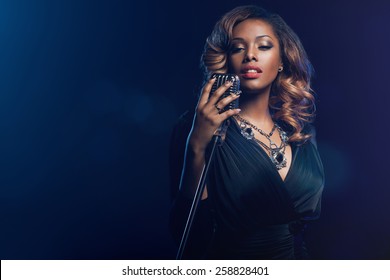 Beautiful African woman singing with the microphone
