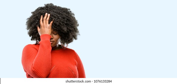 Beautiful african woman stressful keeping hand on head, tired and frustrated, blue background