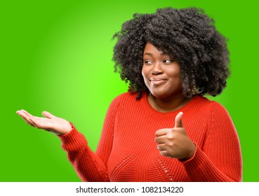 Beautiful African Woman Thumb Up Holding Something In His Empty Hand And Making Ok Gesture