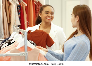 Beautiful African Woman Working At Her Fashion Store Helping Her Female Customer Choosing Clothes Profession Owner Businesswoman People Communication Sales Seller Retail Manager Helpful Assistance