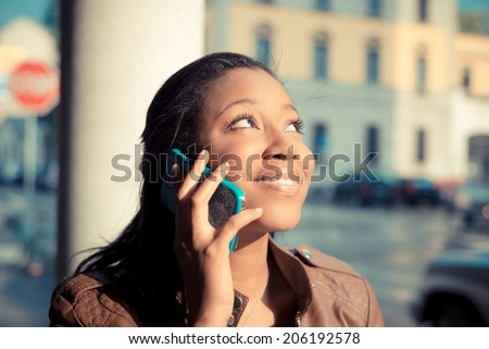 beautiful african young woman using smart phone in the city
