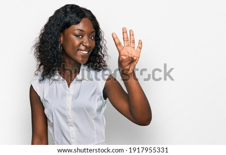 Beautiful african young woman wearing casual clothes showing and pointing up with fingers number four while smiling confident and happy. 