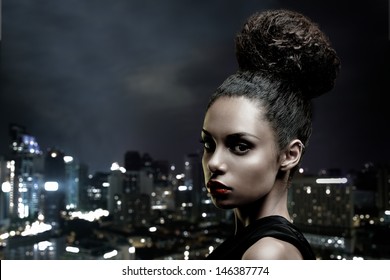 Beautiful African-American Woman In Front Of A Big City Outline.