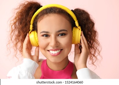 Beautiful African-American woman listening to music on color background - Shutterstock ID 1524164060