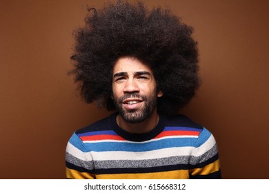 Beautiful afro man in front of a brown background - Shutterstock ID 615668312