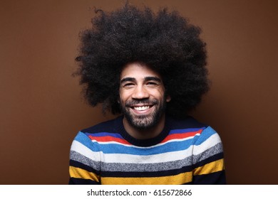 Beautiful afro man in front of a brown background - Shutterstock ID 615672866