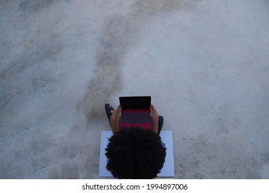 Beautiful Afro-american Woman Sitting With Her Laptop In A Park. The Photo Is Taken From Above And You Can See The Girl Below. Concept College Student