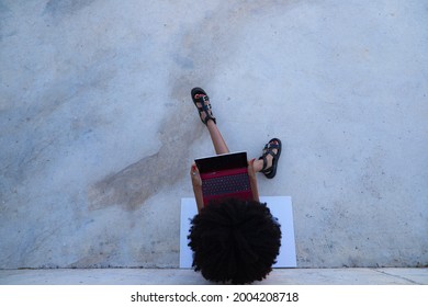 Beautiful Afro-american Woman Sitting With Her Laptop In A Park. The Photo Is Taken From Above And You Can See The Girl Below. Concept College Student