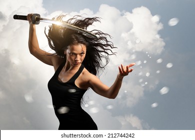Beautiful aggressive Brunette holding katana sword with cloudy environment