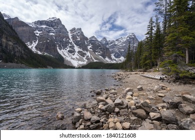 Beautiful alpine lake with turquoise waters surrounded by magnificent peaks, wide shot made on a overcast day at Moraine Lake, Banff National Park, Alberta, Canada
