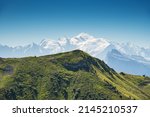 Beautiful Alpine landscape with view of snowed Mont Blanc in French Alps in Morzine area, Haute-Savoie, Auvergne-Rhone-Alpes region, France. People on crest of mountain admiring view. Majestic earth.