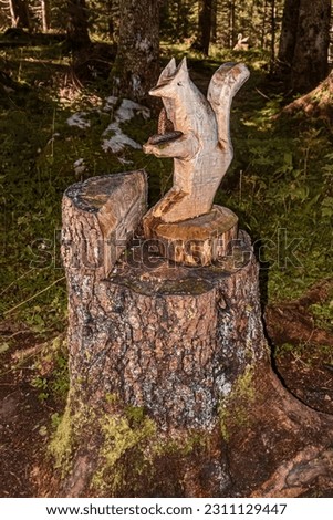 Beautiful alpine summer view with a figure carved from a tree trunk at the famous Ehrwalder Alm near Ehrwald, Tyrol, Austria