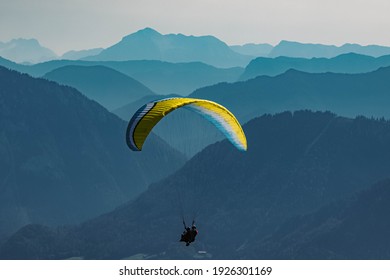 Beautiful alpine summer view with a paraglider and mountain silhouettes in the background at the famous Hochfelln summit, Bergen, Bavaria, Germany