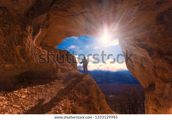 Beautiful amazing\
sunset.  Mountains in north country Russia Caucasus. Unique\
landscape mainsail.  Inspiring travel man. Old nature cave. Active\
sport hobby. Spelunking quest\
panorama.