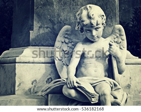 Beautiful angel child statue holding a lyre under his arm and a book on his knees. From Baroque town of Noto, Sicily. 