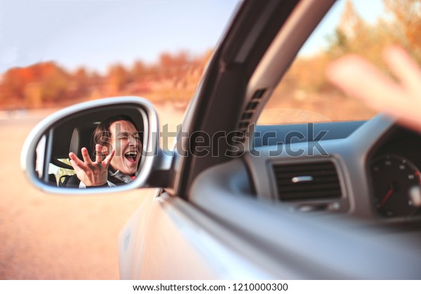 Beautiful angry young woman
screaming in her car. Concept nervousness and anxiety in car
traffic.