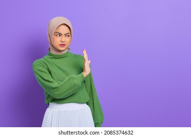 Beautiful annoyed Asian woman in green sweater makes stop gesture, demonstrates rejection isolated over purple background - Powered by Shutterstock