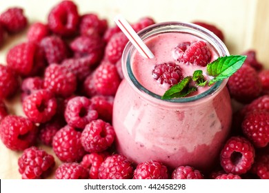 Beautiful appetizer pink raspberries fruit smoothie or milk shake in glass jar with berries background, top view. Yogurt cocktail. Close up. Natural detox. Liquid ice cream.  - Powered by Shutterstock