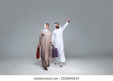 Beautiful arab middle-eastern happy couple of lovers wearing traditional abaya and kandora in studio - Arabic muslim adult people bonding and having fun in Dubai, United Arab Emirates