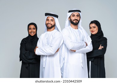 Beautiful arab middle-eastern women with traditional abaya dress and middle easter man wearing kandora in studio - Group of arabic muslim adults portrait in Dubai, United Arab Emirates - Shutterstock ID 2310442509