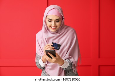 Beautiful Arab Woman With Mobile Phone And Credit Card On Color Background