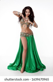 Beautiful Arabian belly dancer isolated studio portrait. Sexy asian woman in bellydance dress. Exotic dancer with jewelry and bright makeup. Sensual long hair brunette girl bellydancer with jewels