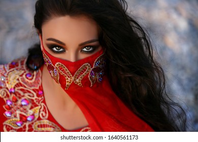 Beautiful Arabian bellydancer dancing at desert outdoor portrait. Bellydancer in jewelry at sand beach. Belly dancing. Young Turkish girl belly dance artist. Arabic woman with makeup and long hair
