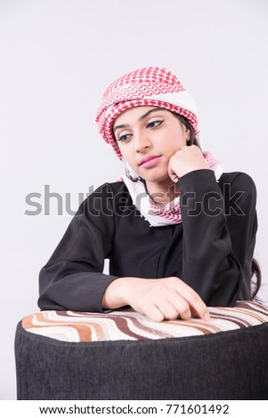 Beautiful Arabic Girl in traditional dress sitting at home