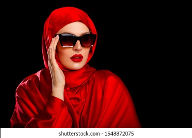 Beautiful Arabic young Woman in Red head scarf. plump red Lips. Portrait Arab Girl hidden under Hijab, face under dark  glasses. isolated. sexy lips. Makeup. Beauty. Lip make-up. black background    