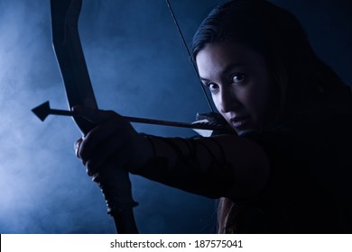 Beautiful Archery Woman Aiming, Smoky Background