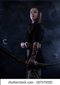 Beautiful archery woman and smoky background