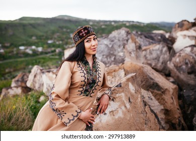 Beautiful Armenian woman in the national costume of Taraz on the background of rocks.