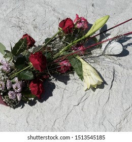 Beautiful arranged flower bouquet with Red Naomi roses, Lilium Longiflorum, Chrysanthemum Santini, Gypsophila and Deep Purple roses. The bouquet is decorated with a white heart at the bottom. - Powered by Shutterstock