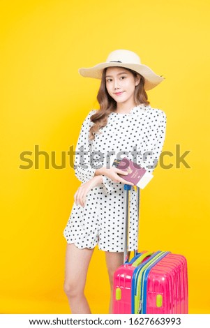 beautiful asia woman happy smiley holding passport bording pass. tourist girl standing with luggage with yellow background.