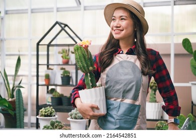 Beautiful Asia woman holding cactus in small shop cactus  - Powered by Shutterstock