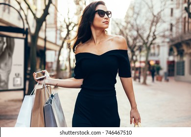 Beautiful Asia Woman Walking On The Street With Shopping Bags.  Trendy Female Model Outdoors In City Road With Shopping Bags.