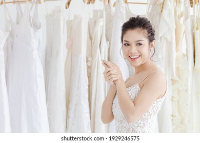 Beautiful Asian bride happy with bridesmaids together help each other to fit elegant lace dress, wedding dress maker try to fit the bride suit in wedding studio or Wedding dress shop store - Powered by Shutterstock