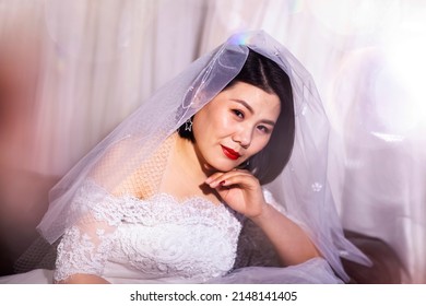 Beautiful Asian Bride Wearing Wedding Dress In Fitting Room