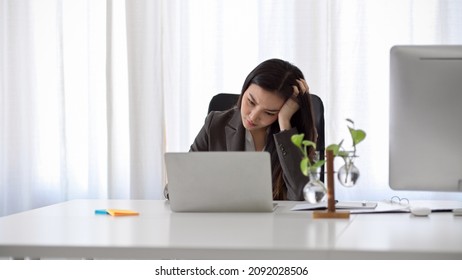 Beautiful asian business woman having a problem on her laptop computer. Unhappy or unsatisfied female worker.
