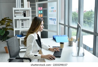 Beautiful Asian Business Woman Looking At Computer Laptop Screen To Working In Office 