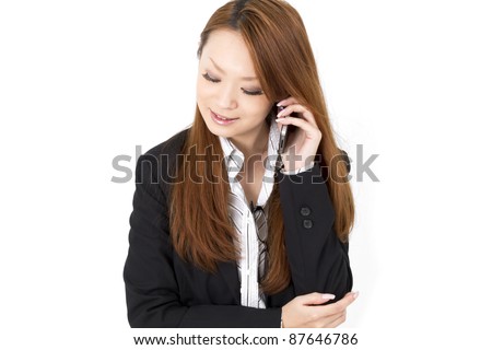 Beautiful asian business woman using a cellular phoen.