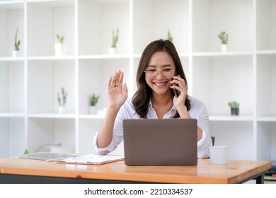 Beautiful Asian Businesswoman Having Fun On The Phone For A Video Call With A Customer In The Office.