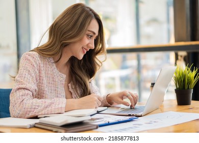 Beautiful Asian Businesswoman, Professional Millennial Woman Or Female Financial Analyst Working On Financial Graphs And Chart Data In The Office.