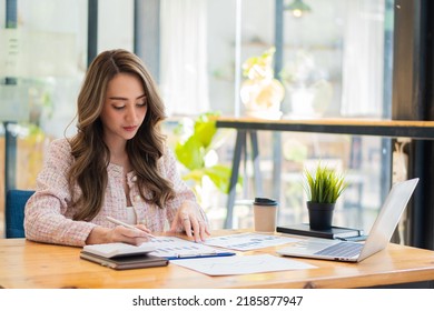 Beautiful Asian Businesswoman, Professional Millennial Woman Or Female Financial Analyst Working On Financial Graphs And Chart Data In The Office.