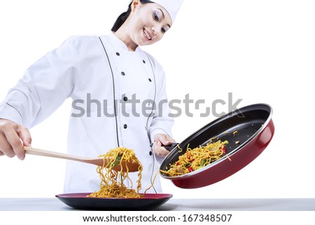 Beautiful asian chef cooks fried noodle. Isolated on white background