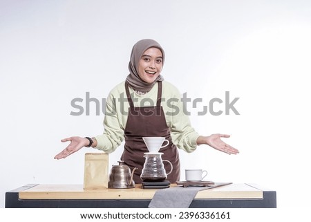 Beautiful Asian coffee shop owner in hijab standing showing coffee maker equipment on the table isolated on white background
