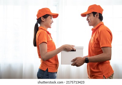 Beautiful Asian Delivery Woman In An Orange Uniform Send Package Products For Assistant In Office. Domestic And International Transport And Logistics