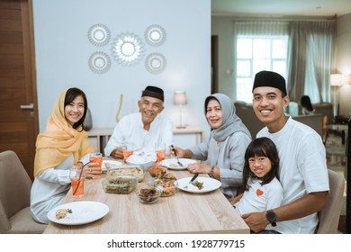 beautiful asian family enjoying their iftar dinner at home. ramadan kareem islam break fasting tradition