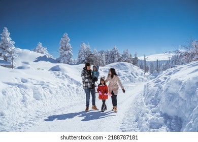 beautiful asian family walking together in landscape cover with wonderful snow
